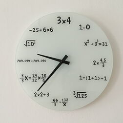 Das Zifferblatt einer Uhr, die statt jeder Uhrzeit eine Rechnung anzeigt, z.B. „-25+6x6“ für 11 Uhr